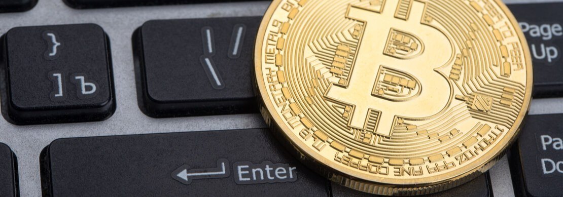 a bitcoin sitting on a computer keyboard