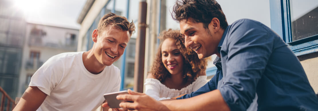 three friends playing online casino games together on a phone