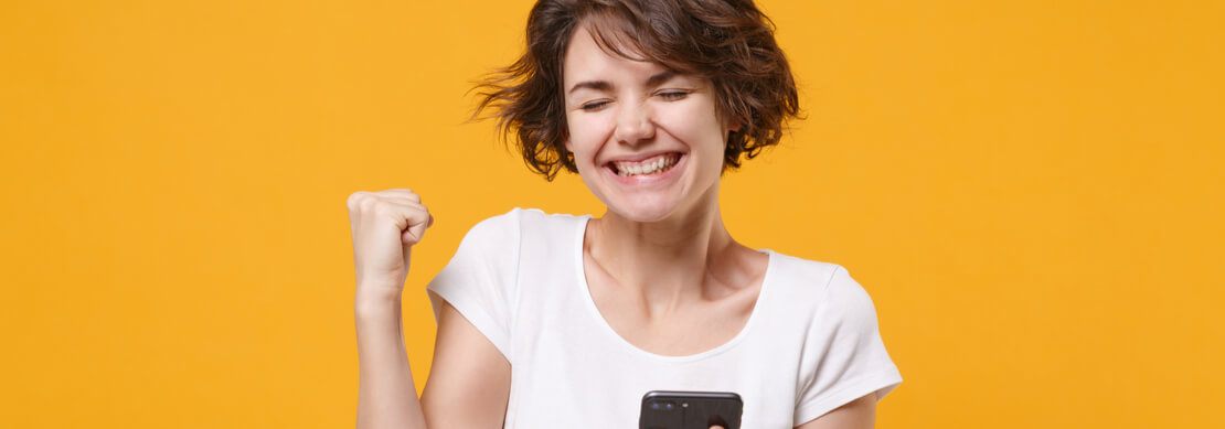 happy woman after a win playing on her phone