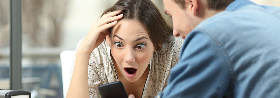 couple playing on their phones with him showing her a win and her freaking out