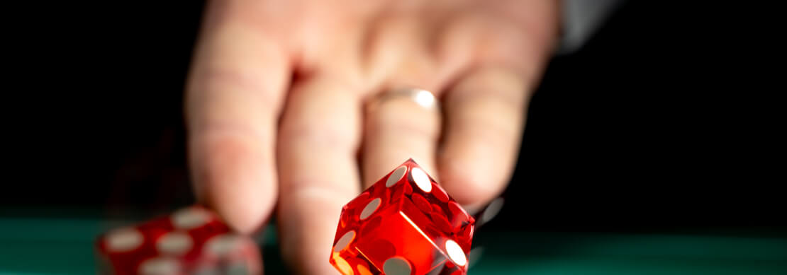 man throwing two red dice playing craps at Jackpot Capital