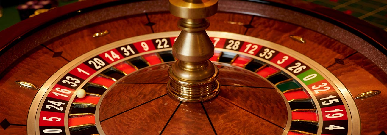 a beautiful roulette wheel in red and black with  reddish-brown hardwood finish