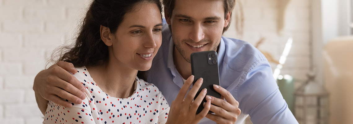 a young couple calmly playing mobile casino games in their living room