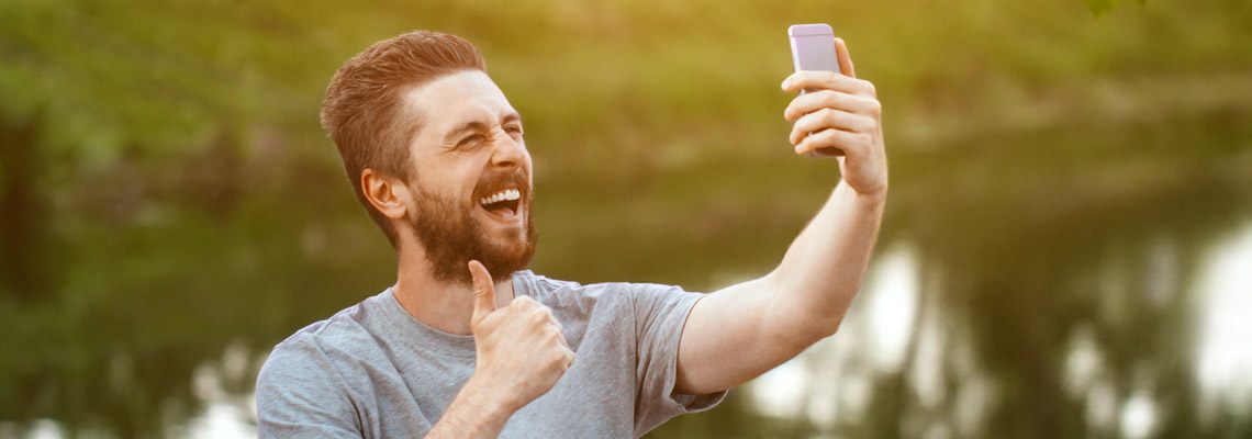 young man taking time off from bicycling in nature to play a few spins on his online casino mobile gaming platform