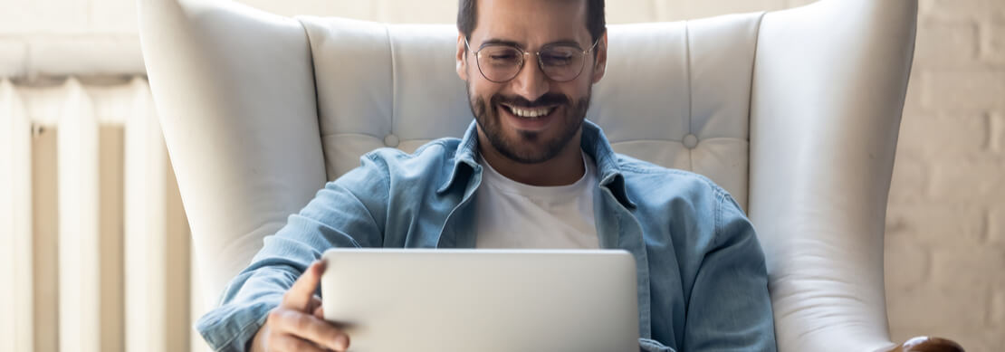 man sitting in an easy chair with his laptop